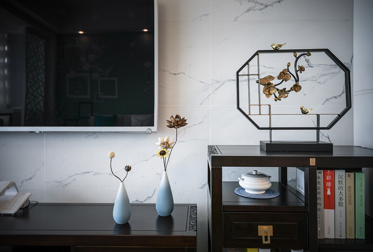 客廳整體風(fēng)格采用新中式家具，配水墨畫(huà)風(fēng)格的電視背景墻，簡(jiǎn)約的沙發(fā)背景墻餐廳做了一些中式花格的點(diǎn)綴，使中式與現(xiàn)代的完美結(jié)合，在顏色上做了統(tǒng)一，配上精致的木裝飾，玄關(guān)柜的鏤空的中式點(diǎn)綴，讓整個(gè)空間更加的唯美。
