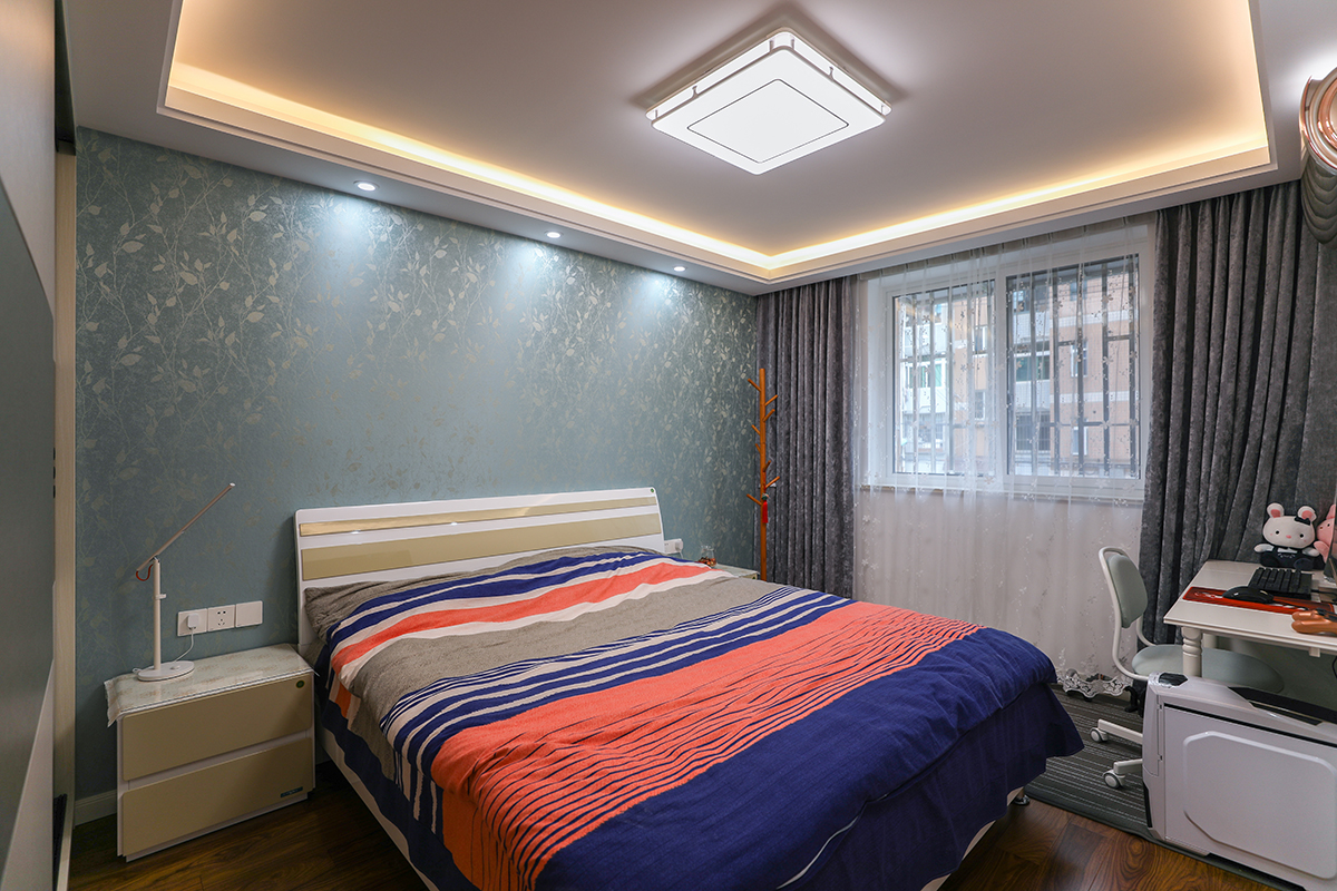 主臥精心挑選了簡約雙人床，輔以品質感滿滿的線條床品，實用性和美觀性相得益彰。由于樓層不高，外面的綠植影響到室內的采光，因而需借助大面積的窗戶和光源提升亮度。
