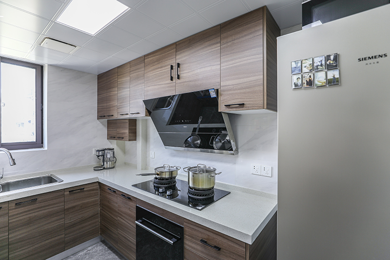 廚房的設計同樣采用了色調一致的黑白灰顏色，設計元素也是直線條，中間的燈具采用了圓形金色，為了呼應下邊的廚臺也做成了橢圓形，搭配的非常巧妙。
