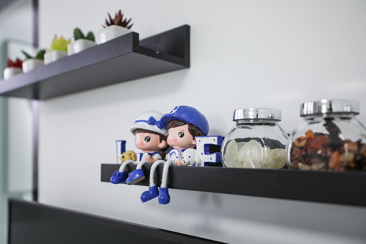 電視背景墻上錯位排列木隔板放置植物和玩偶，一深一淺的視覺對比進一部豐富墻面的細節
