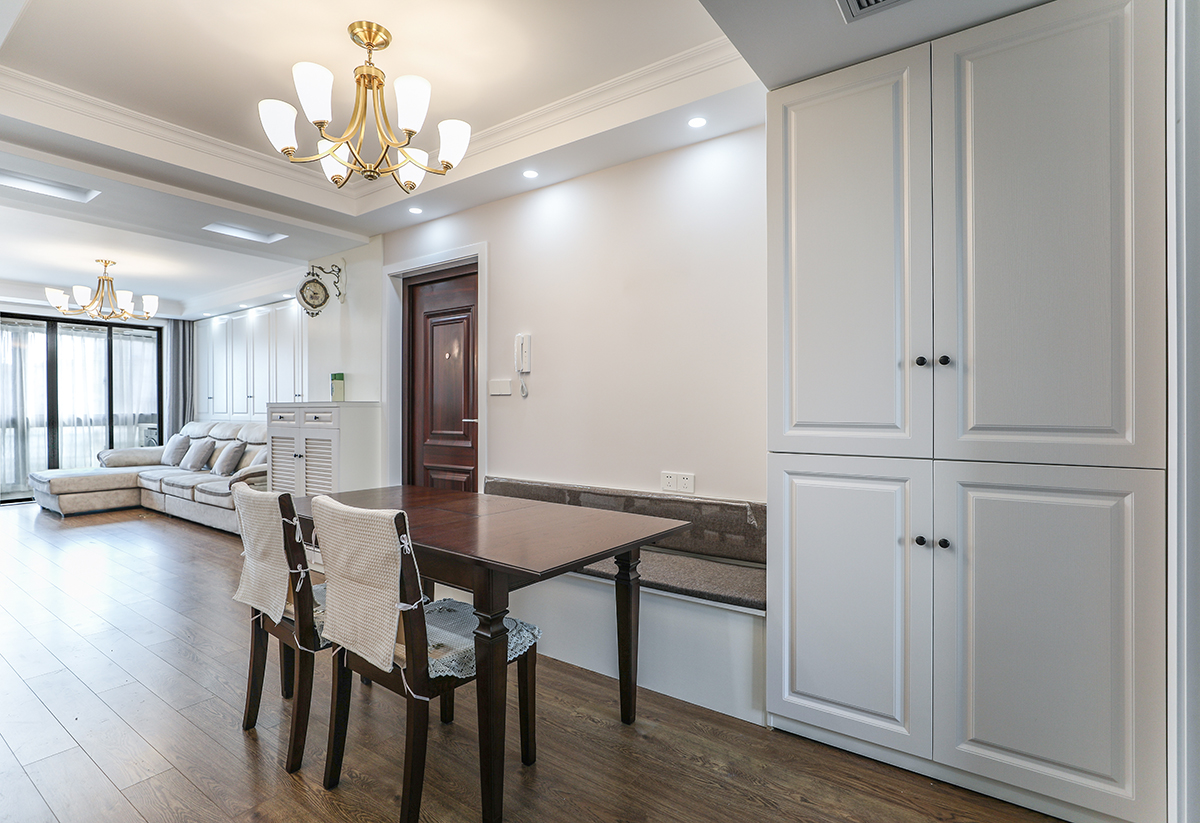 餐廳使用卡座代替餐椅，與卡座一體的白色餐邊柜，和深色木質餐桌形成鮮明對比，色調更鮮活輕快。
