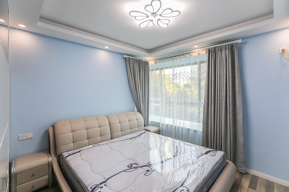 主臥室采用飄窗加以咖色的窗簾使得本身單調的色彩空間立馬體現出色彩的多樣話和柔和度，使得整體色彩非常的舒服，給人以非常舒服的休息環境，皮質的家具使得色彩反差非常的大，立體效果非常的舒服，體現業主的追求極簡自由的生活。
