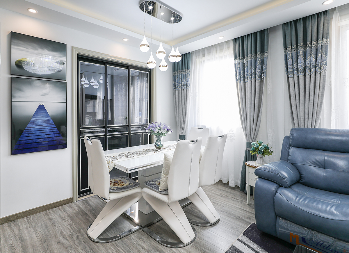 黑框移門白色線條勾勒黑與白，與白色墻面灰色地板互相對應。沉穩的地板配色更突顯白色軟包桌椅的質感和檔次。藍與灰的裝飾畫與整體的空間配色互相呼應，白色墻體也不會有過多的留白。
