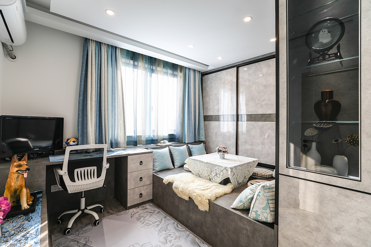 地面軟質地毯與全屋定制榻榻米做到軟硬的平衡，空間不會因過多的板式家具而顯得銳利。黑色溝邊灰色板面勾畫出整體空間的構架。升降式塔塔米休閑時約三五個好友一起享受閑暇時光。
