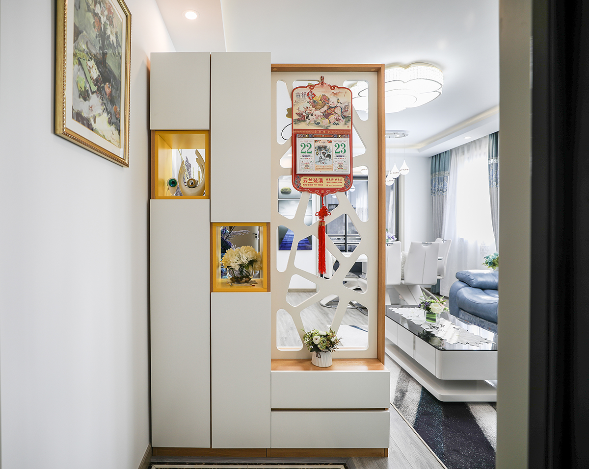 進門玄關柜，藏而不露，鏤空處理讓光線滲透到玄關。黃色的點綴降低了空間的冰冷，柜旁的矮柜使得換鞋更為便捷。
