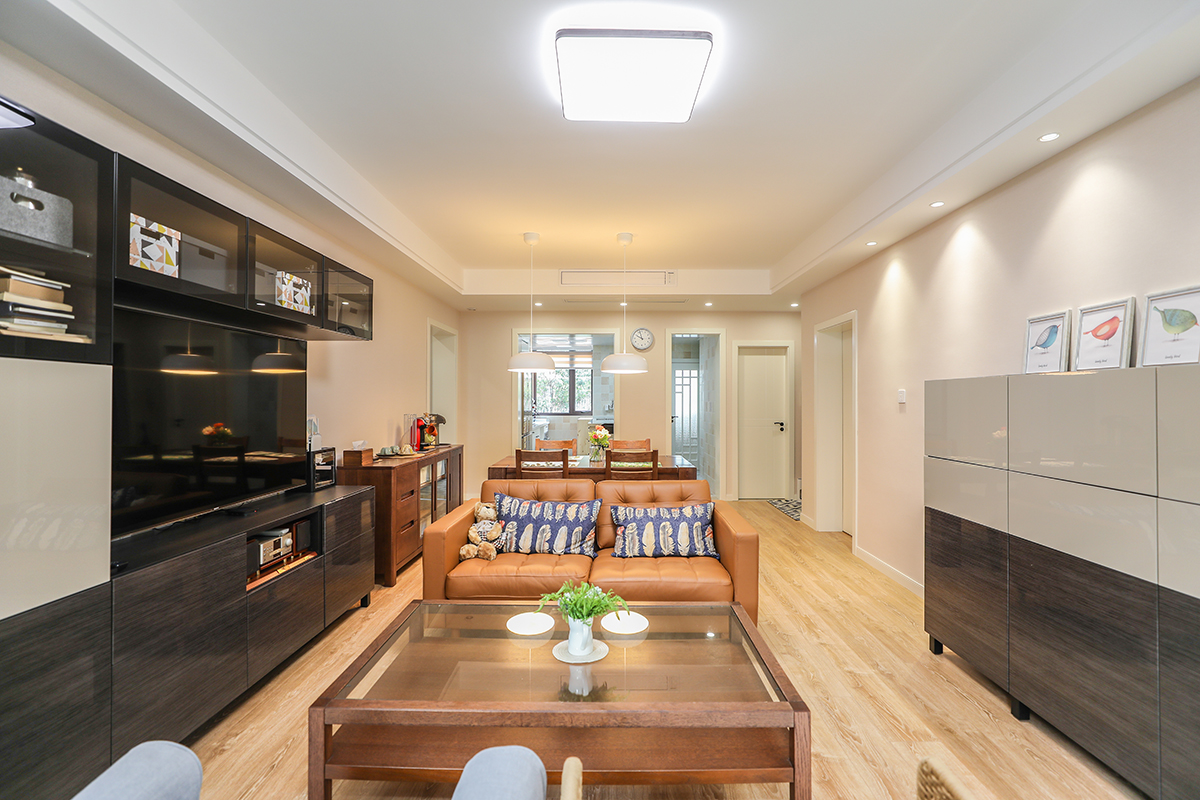 業(yè)主在選擇家具的時候，以簡單的線條為準。比如黑色的電視柜、咖啡色的沙發(fā)，還有一只書香氣息很重的藤椅，配上原木色地板，整體相結合。把家具的層次，空間的大小，整個客廳的色調(diào)井然有序，很有條理的處理好。原木色的桌椅，放在沙發(fā)背后，配上三個簡潔的簡約燈，整個空間顯得格外和諧。現(xiàn)代室內(nèi)家具、燈具和陳列品的從整體空間的設計主題開始。家具應依據(jù)人體一定姿態(tài)下的肌肉、骨骼結構來選擇、設計，從而調(diào)整人的體力損耗，減少肌肉的疲勞。燈光設計的發(fā)展方向主要有兩大特點：一是根據(jù)功能細分為照明燈光、背景燈光和藝術燈光三類，不同居室燈光效果應為這三種類型的有機組合；二是燈光控制的智能化、模式化，也即控制方式由分開的開關發(fā)展為集中遙控，通過設定視聽、會客、餐飲、學習、睡眠等組合燈光模式來選擇最佳的效果。對于陳列品的設置上，應盡量突出個性和美感。
