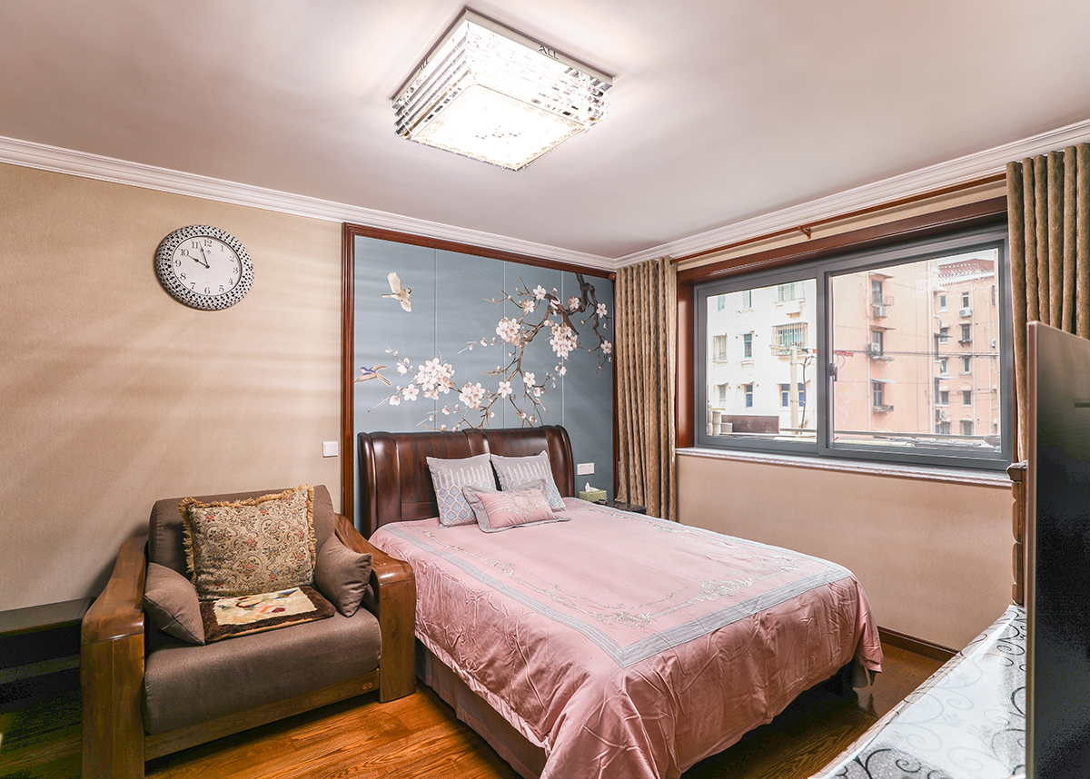 主臥將柚木色和咖色進行了穿插配色，實木的材質配上花鳥的背景，給人以古代人們田園般的生活休閑生活，一把躺椅，一盞茶，生活的樂趣淋漓盡致
