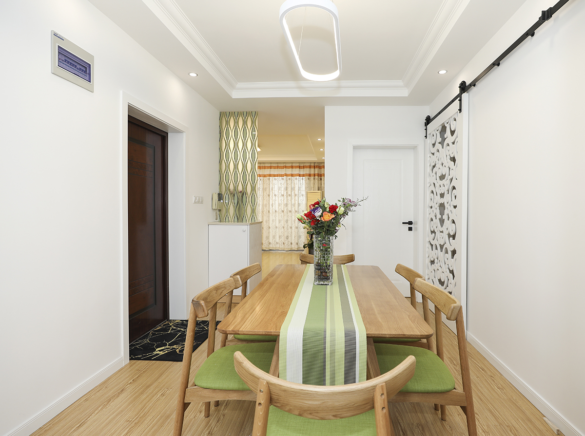 餐廳的背景采用了白墻加上鏤空花格谷倉門，作為高端的背景材料增加了整體的檔次，純白色的吊燈奢華低調。
