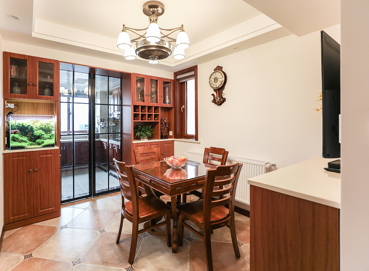 對稱的酒柜增加儲物空間，同時隔開了廚房與餐廳，使功能區劃分明確，增加美感。餐廳采用仿古磚，仿古燈，與墻上的擺鐘相得益彰增加了美式風格的韻味。就餐時具有別樣情懷。
