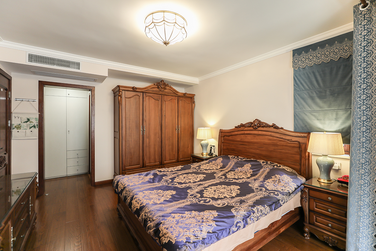 臥室胡桃木色家具彰顯沉穩，家具大氣有質感，進而延伸美式韻味。隱蔽式衣帽間貫穿衛生間，整體感更強，增加了儲物空間的同時合理利用空間，讓衣帽間和衛生間完美過度，套間讓生活更便利。
