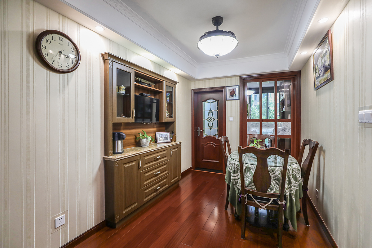 餐廳部分利用了原來門洞的空間做了一個餐邊柜，既美觀又實用且不占空間。由于風格較為簡約，家具一般選用胡桃木家具，這樣更能突出木質的本身特點，在不同角度上產生不同的光感。
