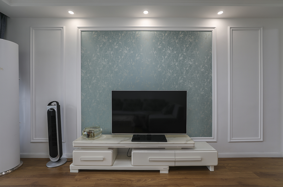 該套房客廳是由原來的臥室改造而成，光線不太明亮，所以整體以白色為主，配上灰色的沙發，現代時尚的吸頂燈，使空間干凈清爽、豐富多彩，不單一呆板。
