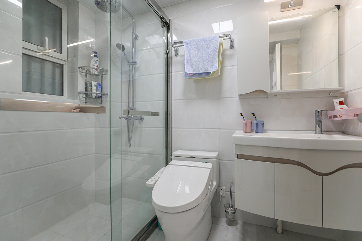 衛生間以實用為主，一般分為三大功能區，盥洗區、廁所區、浴室區。盥洗在前，廁所居中，浴室在后。該空間各大功能區布置的井井有條，色調上白色的潔具、白色的瓷地磚配上暖色調的實木浴室柜，使衛生間既干凈又溫馨。