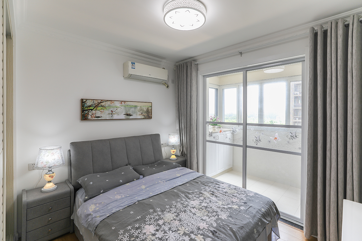 主臥的空間相對較大，右側緊鄰推拉式陽臺，使得整個房間明亮通透，背景墻上掛著一副典雅得田園生活的山水畫，使層次更為豐富一些，整體的家私和風格的感覺延續客廳，注重品質和空間的感受。
