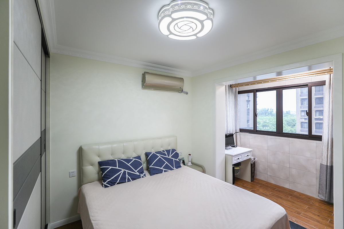 臥室簡潔，清爽，陽臺木紋磚與臥室地板相呼應，既滿足陽臺有洗衣機水斗會潮濕，又使視覺上臥室陽臺一體增加空間感，實用與美觀兼顧
