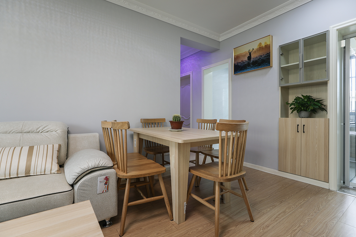 餐廳延續(xù)了客廳的設(shè)計(jì)風(fēng)格，讓整個空間顯得開闊而明亮，利用每一寸空間，原先門洞處增加了餐邊柜，門板與餐廳桌椅相呼應(yīng)。上柜玻璃櫥窗，增加空間的延伸感同時起到裝飾作用。
