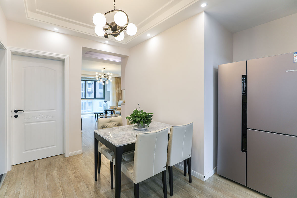 餐廳采用了黑白搭配的餐桌，使得空間非常的簡潔清爽，造型的無意中給餐廳增添一處亮點，藍色的墻面和木紋的地板加以白色的木門使得簡約元素非常的充足，得以空間的最大化。
