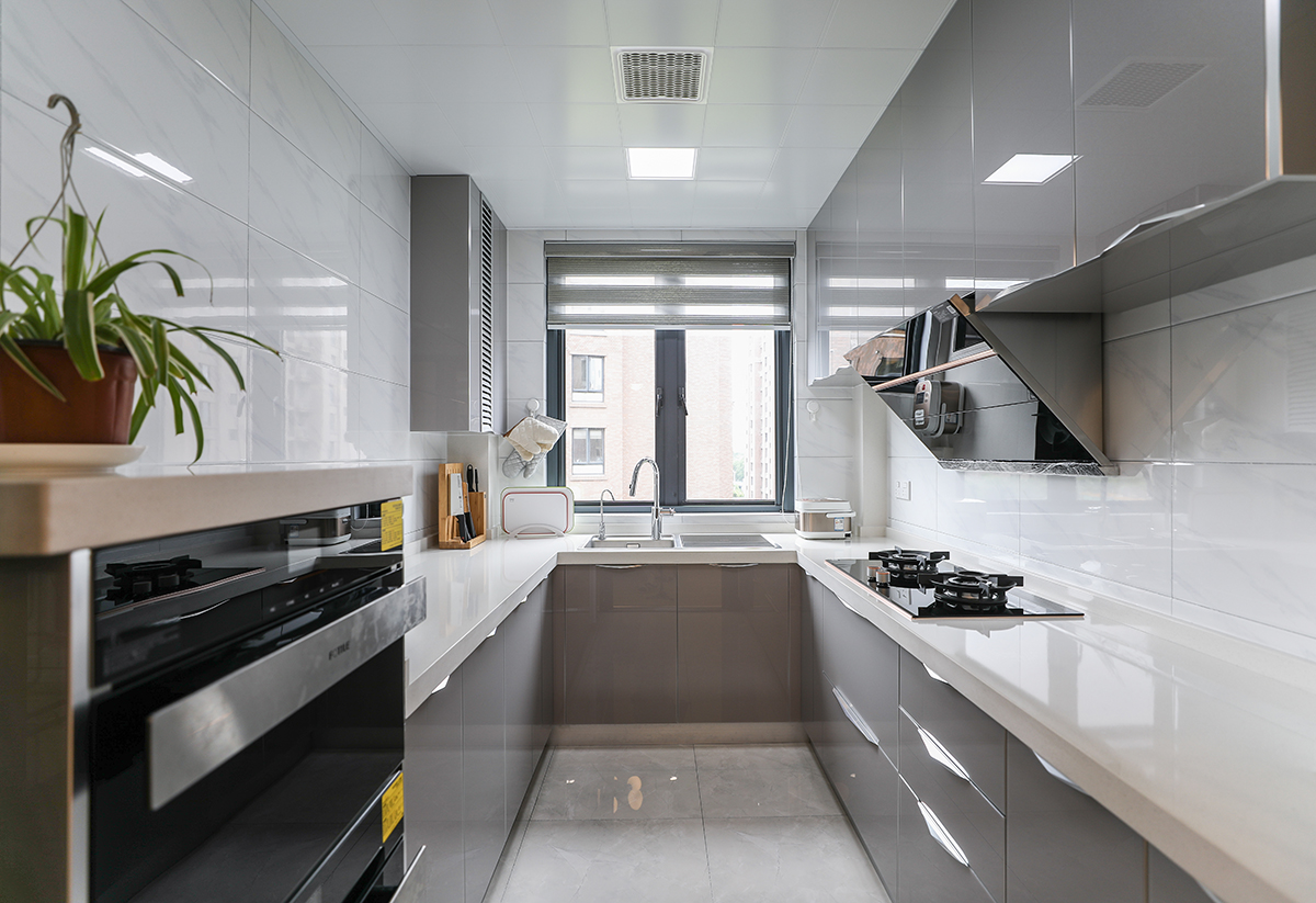 廚房采用灰色色系，充分體現簡約風格，側吸的煙機，不銹鋼臺面和灰藍色櫥柜的合理搭配，顯現出客戶的整潔生活，灰色和白色瓷磚的搭配更加的合理大氣，隨著家庭電器的不斷增加使得廚房在設計上對于電器的需求充分合理的安排。
