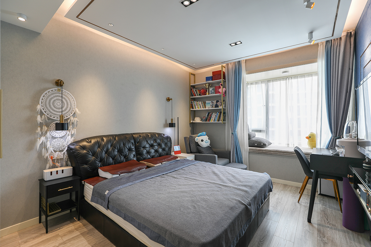 主臥采用了滿吊頂，點光源的設計思路，吊頂下金色不銹鋼與客廳遙相呼應，床頭廢棄了原始常規的床頭柜燈，采用了壁燈，這也大大利用了床頭柜上方的空間。飄窗一角設置了休閑沙發，在繁忙的都市快節奏的工作下，可以坐下來靜靜的喝杯茶，看看書，想想所謂的詩跟遠方，休閑沙發上方的不銹鋼書架也是非常的貼心，既實用又不乏美觀度。
