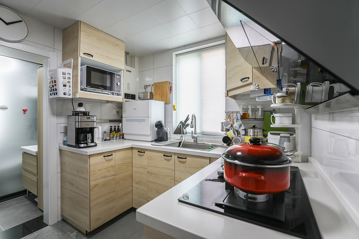 墻磚采用大理石紋理白色瓷磚讓空間顯的干凈整齊，清爽明亮，地磚是灰色的，白灰搭配簡約時尚，櫥柜同時依然采用原木色櫥柜，使整個空間搭配更整體。衛生間采用干式分區，依然用黑色磨砂隔斷來隔離，節約空間的同時，更具有美觀性。衛生間墻地一色的深灰讓整個空間線條硬朗起來，黑，灰，原木色完美融合。
