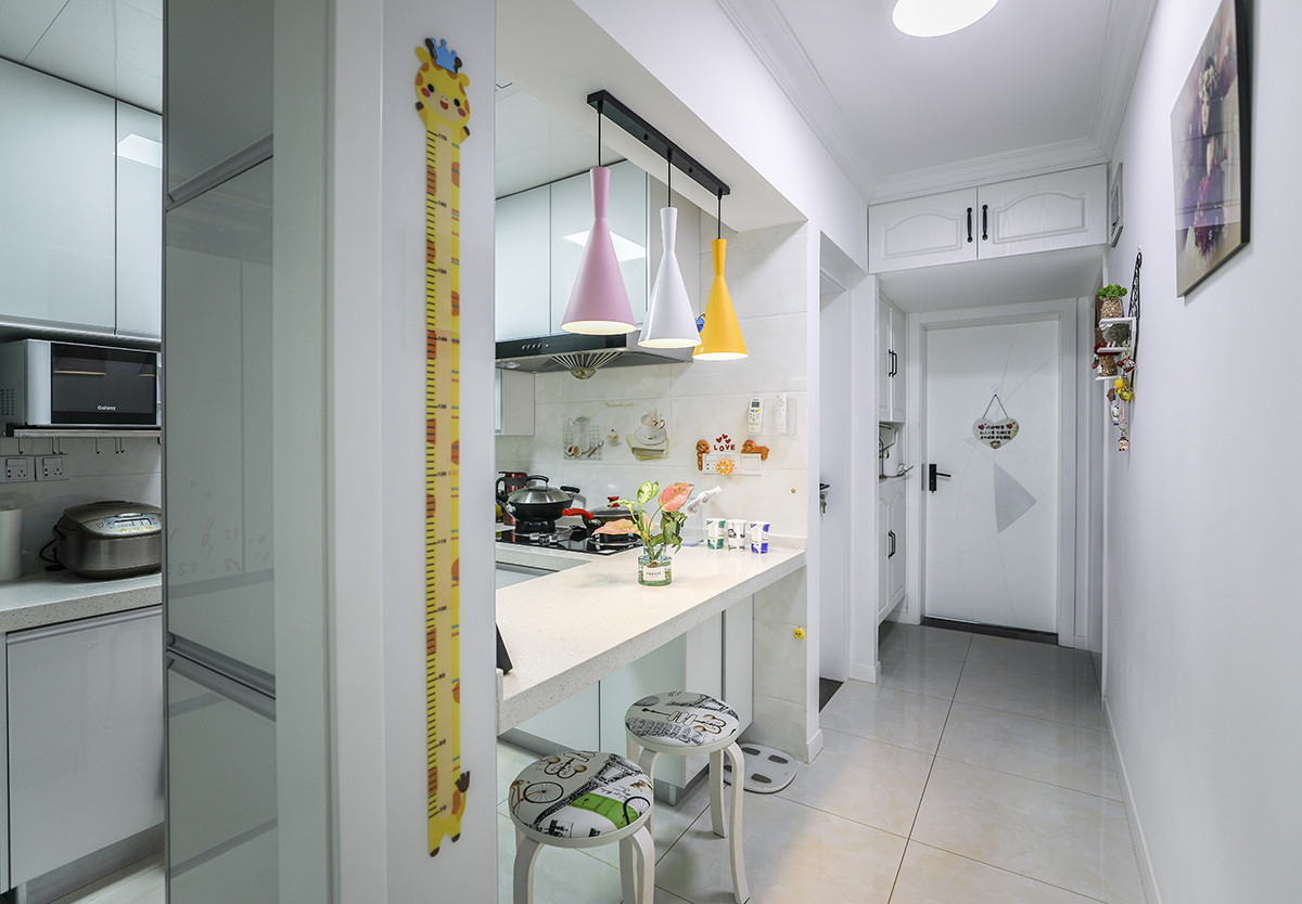 廚房與臥室之間的薄墻向內推移增減廚房及入戶空間。餐廳與廚房相結合。原本主煤氣管位置用立柜包起來。不僅優化了煤氣管，同時增加了儲物空間。吧臺的設計平時三口之家用餐空間完全沒有問題，同時滿足了女主人的烘焙需求。
