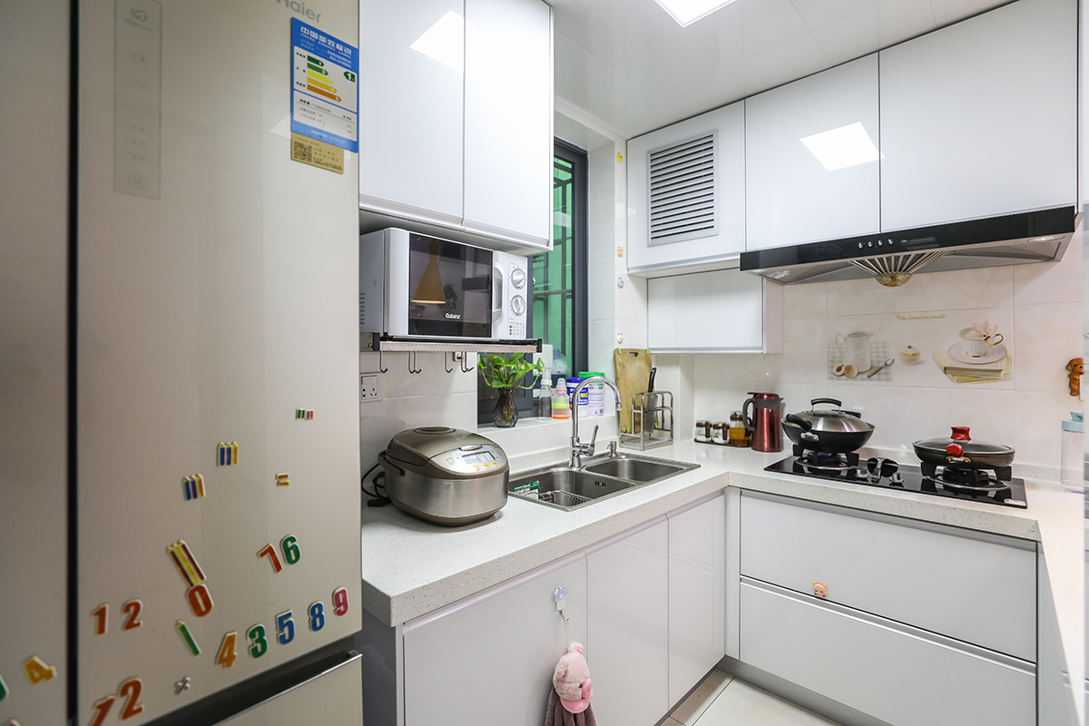 利用每一處可利用的空間。整體廚房配色明亮為主。增加入戶的采光度。整體廚房櫥柜的臺面與吧臺在同一水平高度了。增加了操作空間及置物空間。櫥柜采用晶鋼板門板，易打理同時顯得空間明亮。
