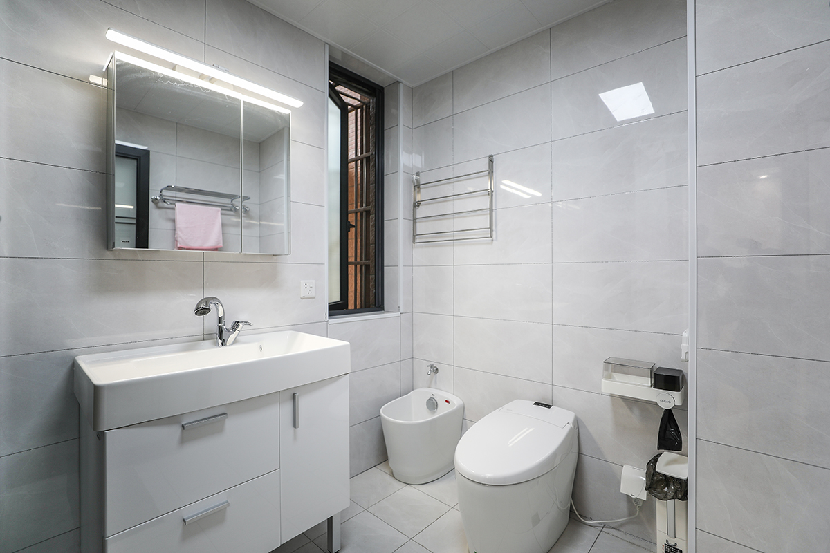 衛生間采用干濕分離，干區用白色實木臺盆柜，體現主人高檔次的生活品味。白色智能坐便器搭配的恰到好處，無不體現了主人優雅的審美觀。
