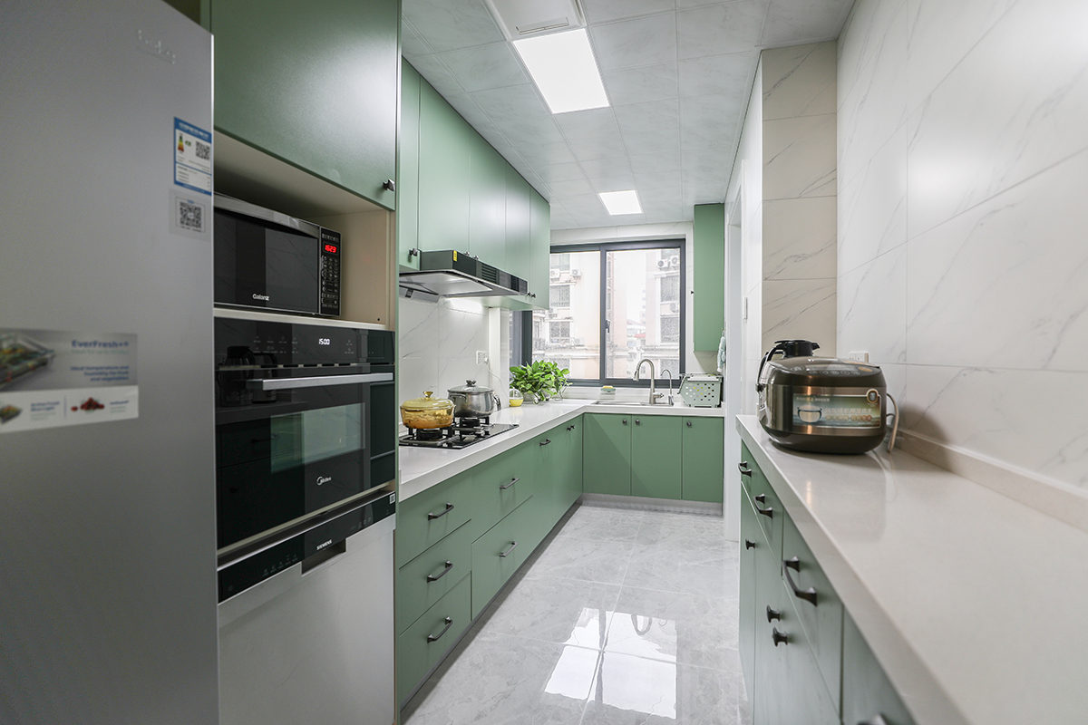 廚房間很大很長，做了左右雙面櫥柜的設(shè)計(jì)。同時(shí)定制了現(xiàn)在比較流行的設(shè)備柜放置洗碗機(jī)烤箱的電器設(shè)備。