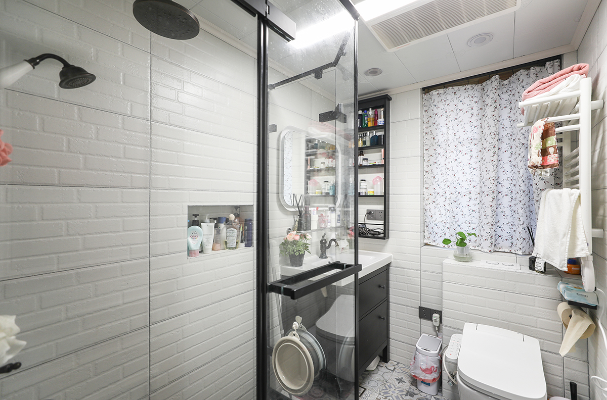 由于空間格局的調整，馬桶選用掛壁式馬桶，排污不會出現堵塞的情況。局部墻面做了壁龕增加了置物空間。地面小花磚墻面仿古磚，增加了空間感。