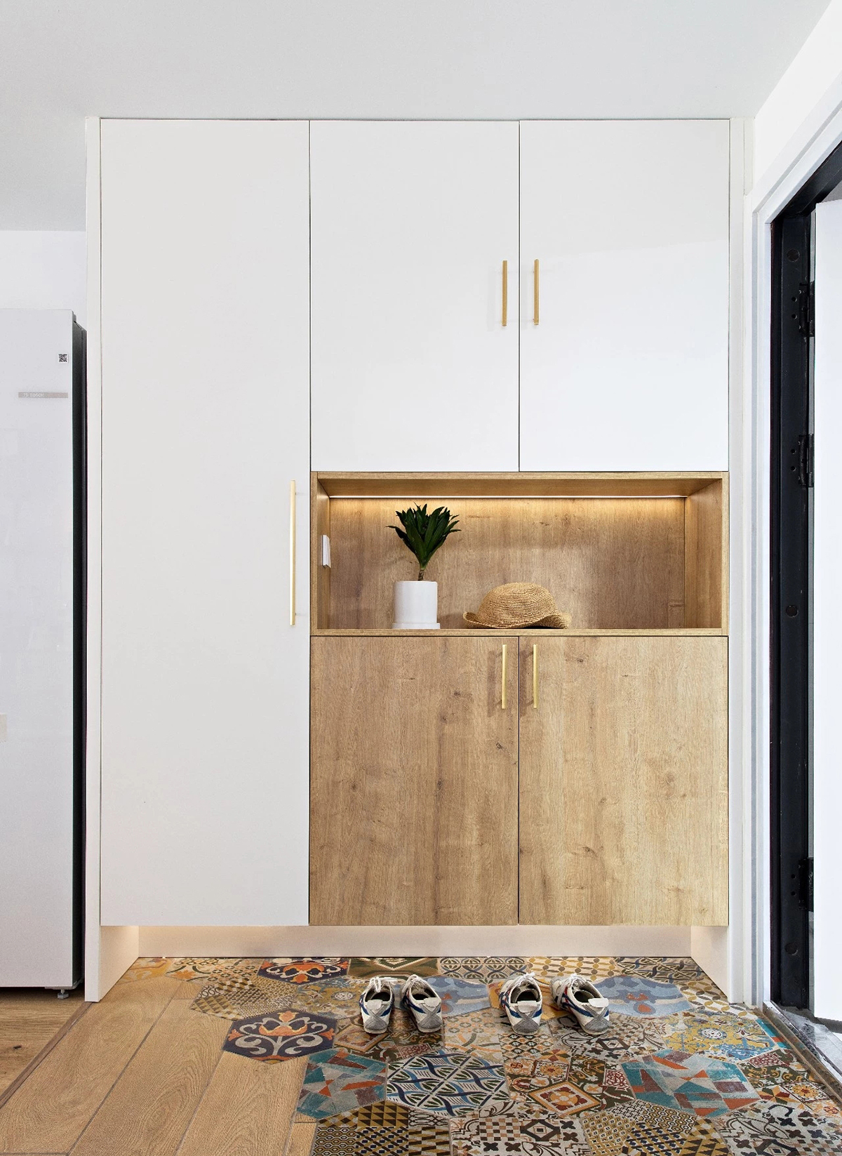 玄關(guān)：好心情從入門(mén)開(kāi)始。六角磚拼接地板，柔和過(guò)渡到室內(nèi)，半高鞋柜組合頂柜是藏在門(mén)口的收納大胃王。底部留空，常用的鞋子隨便擺也不怕亂糟糟。柜下暗藏?zé)魩В瑩Q鞋不用彎腰就能看得清。
