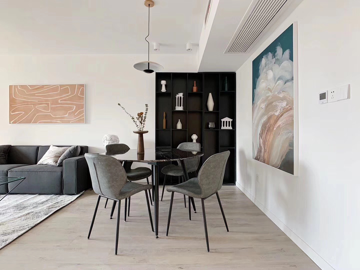 餐廳區(qū)域正對著進(jìn)戶門，餐廳后面的裝飾柜選擇黑色，一是因為空間色調(diào)清一色偏灰，無法突出主體，在一個裝飾柜的作用正好可以作為進(jìn)門的一個亮點，也可以作為酒柜使用。
