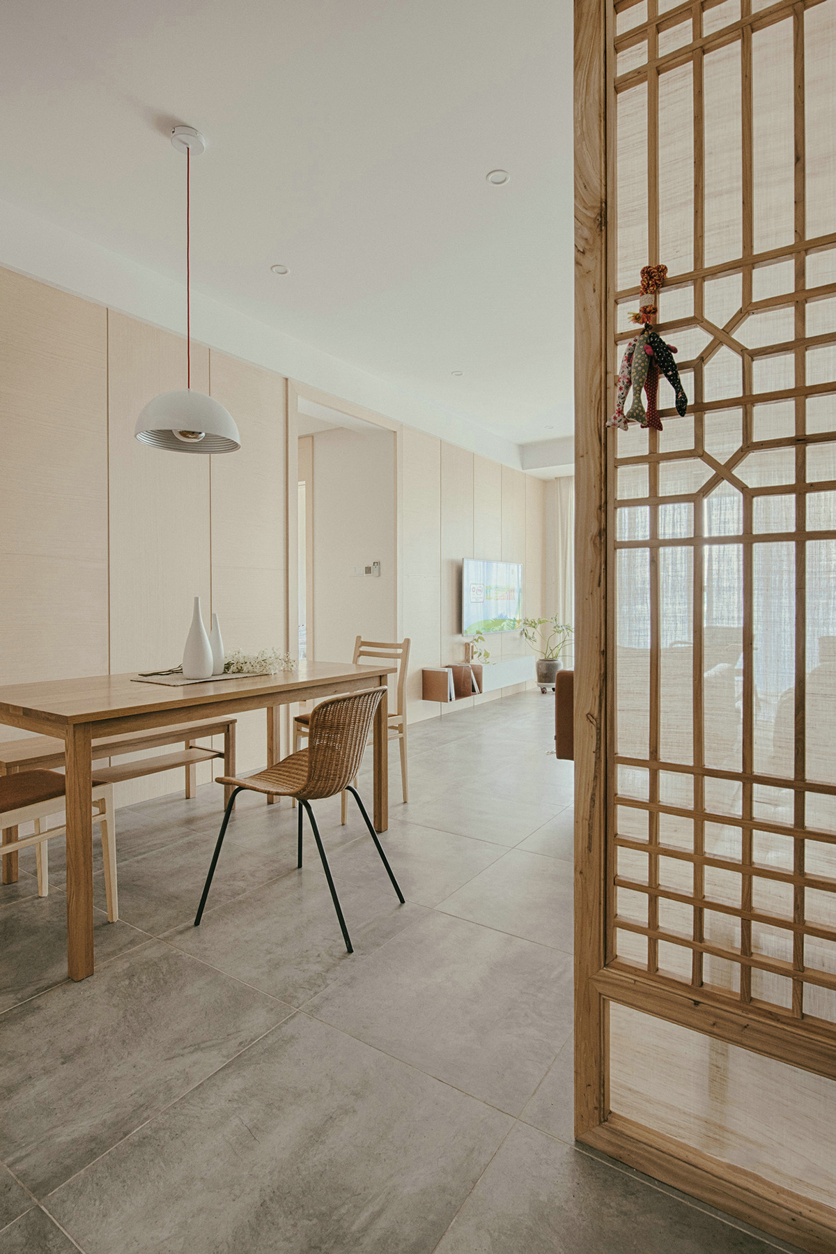 進門玄關空間略小，除了懸掛式鞋柜外，把空間分配做了隔斷，進門后并不會一眼望穿整個空間。鏤空隔斷在增強隱私性的同時又舒緩了視野，隔斷背后放置一架黑色的鋼琴，注重生活品質的業主，更喜歡平時練練鋼琴看看書，認真地思考生活的每一個細節，增添了生活的儀式感。
