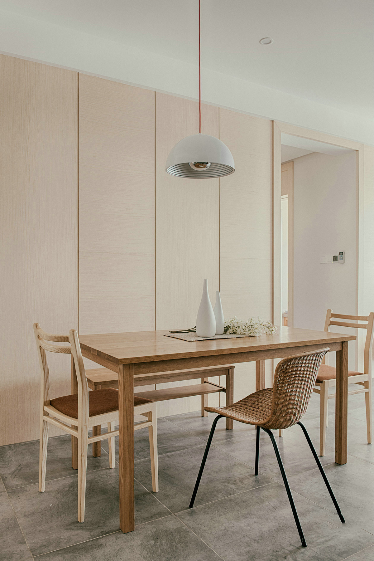 餐廳選用大面積淺系原木作為背景墻，與餐桌餐椅的材質顏色達到了統一，搭配十分和諧，原木色貫穿空間，日式原木氣息干凈又清新。
