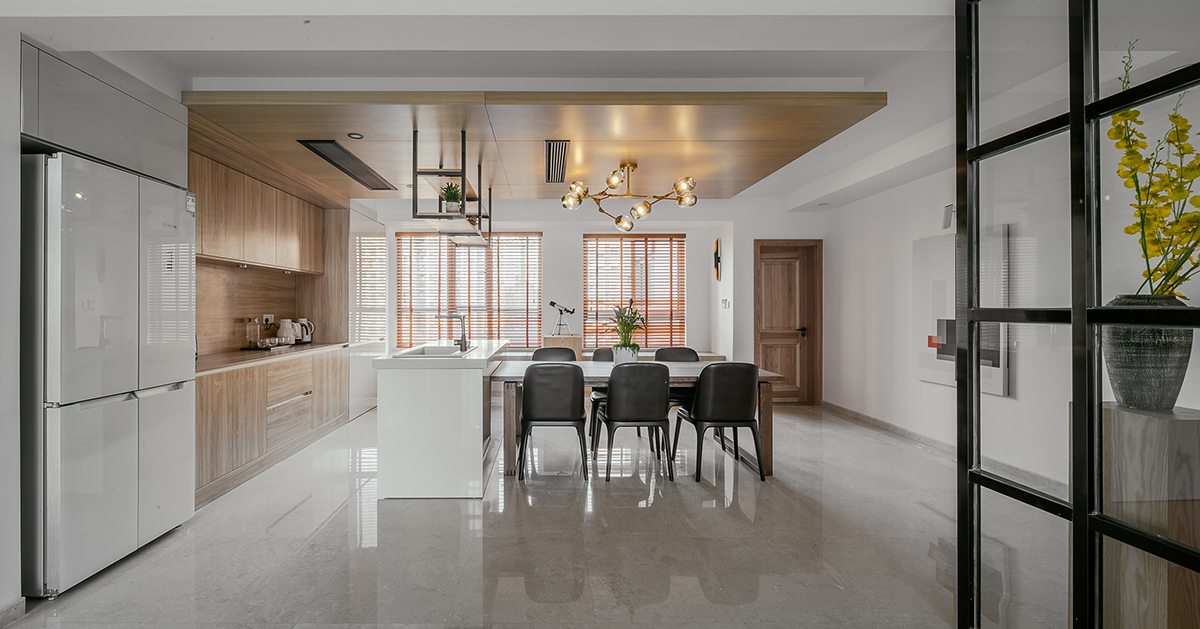 木飾面是貫穿整個(gè)空間的，顏色層次是黑白灰+木色的基調(diào)。大面積白色會(huì)使空間沒有很冷，所以用木色的溫潤(rùn)來(lái)調(diào)節(jié)整個(gè)空間溫度。讓家的感覺更溫馨。櫥柜與頂面不是一家生產(chǎn)，在施工中先確定了櫥柜顏色。帶著樣板去定制頂面顏色，整體效果基本一致。櫥柜和吧臺(tái)的位置就是原來(lái)的空中花園，打通后空間開闊，可以和客廳統(tǒng)一。為了配合整體簡(jiǎn)潔干凈的感覺，窗簾我選用木色百葉窗。透光和隱私性和布藝窗簾同等。右側(cè)的廚房是紅橡制作，為了保證實(shí)木的本質(zhì)只做了清漆。顏色質(zhì)感是市場(chǎng)銷售產(chǎn)品所達(dá)不到的。
