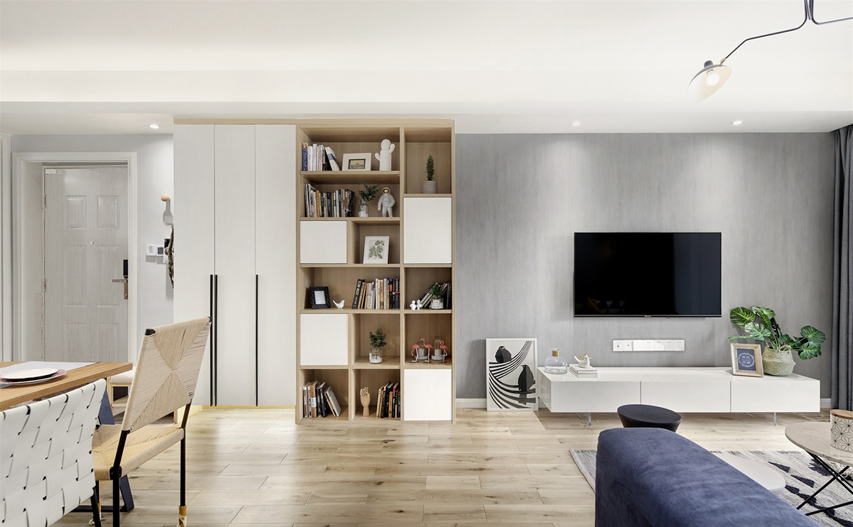 客廳以灰色墻面搭配原木色地板，簡約的背景墻設計，看起來干凈清爽，同時搭配撞色系的藍色沙發，局部亮色點綴，起到畫龍點睛的作用。
