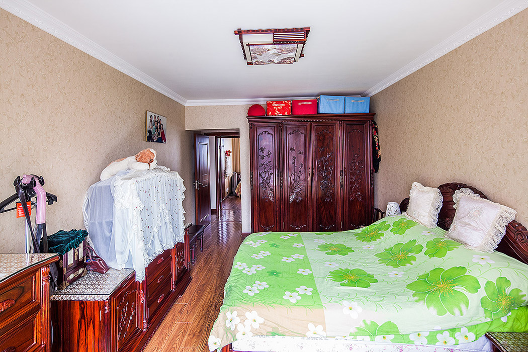 主臥的中式格調，增添幾分暖意，傳統的中式家具，簡約的生活，使整個居室在濃濃古韻中滲透了幾許現代氣息
